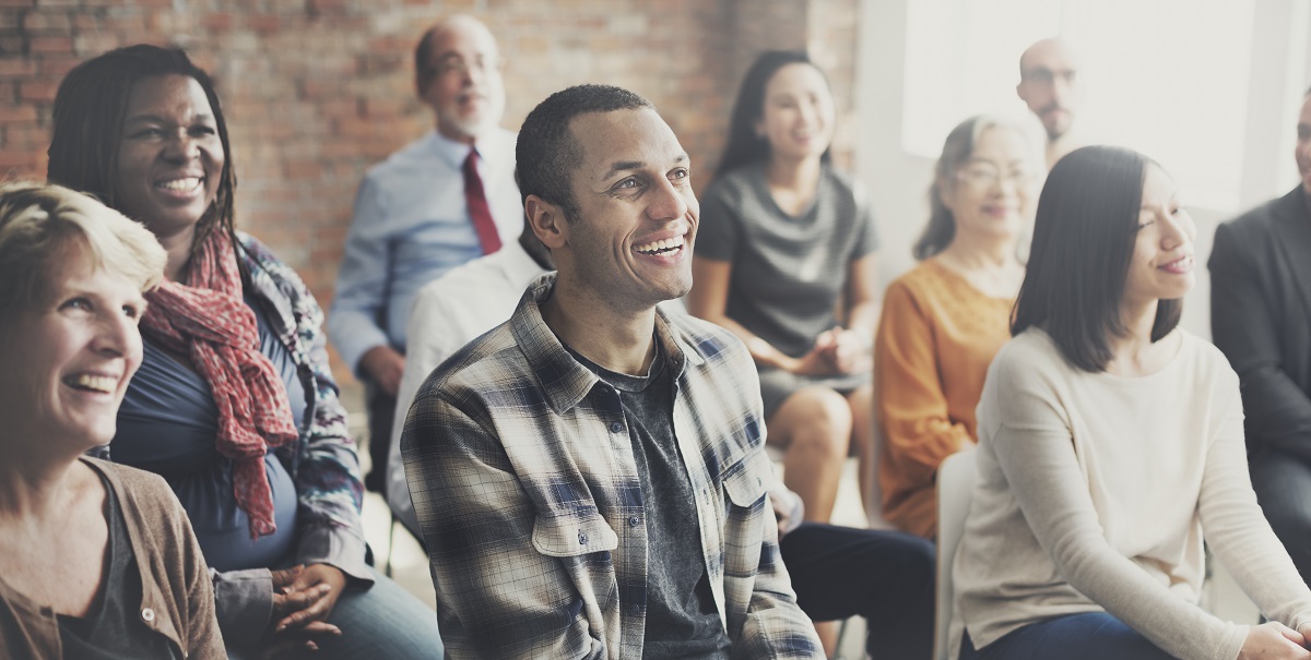 people smiling and laughing at the speaker in an event