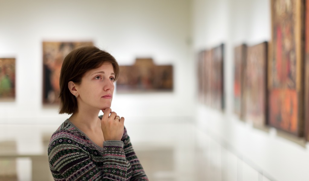 woman looking at the paintings in the art gallery