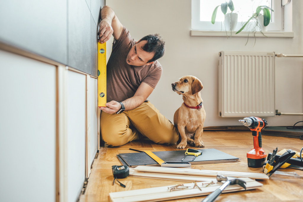 man fixing house with dog