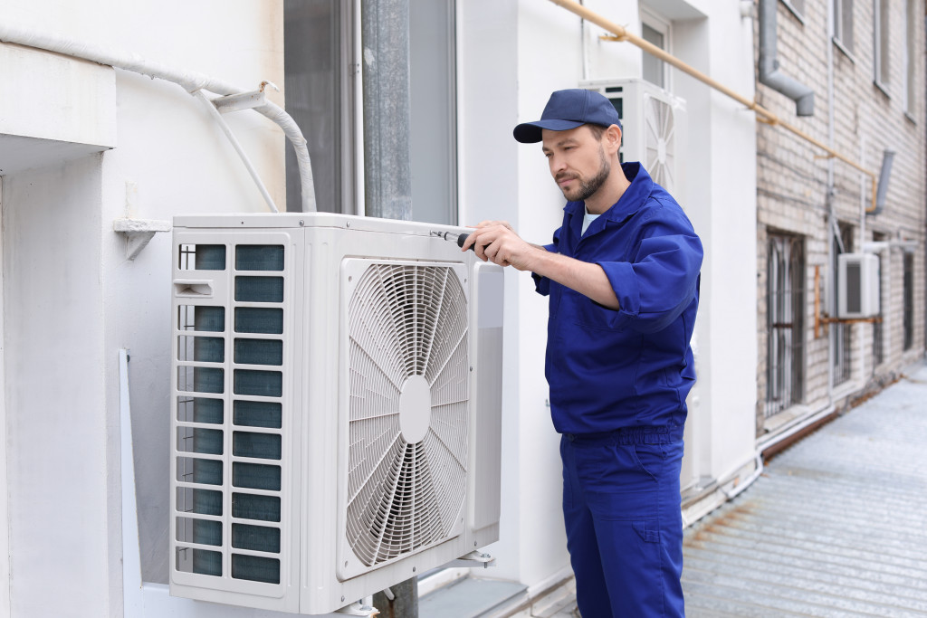 a person checking an air-conditioner