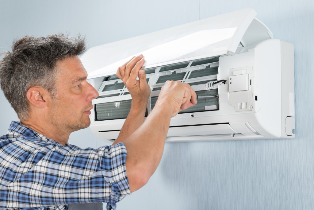 Mid-adult Male Technician Repairing Air Conditioner