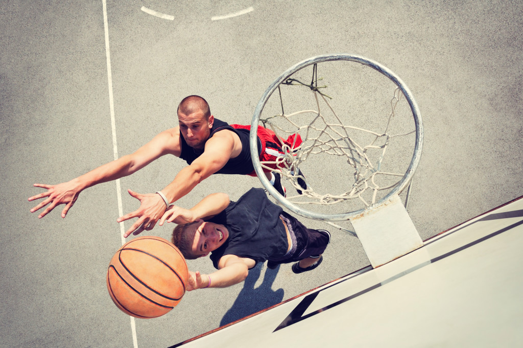 Two guys playing basketball outdoors