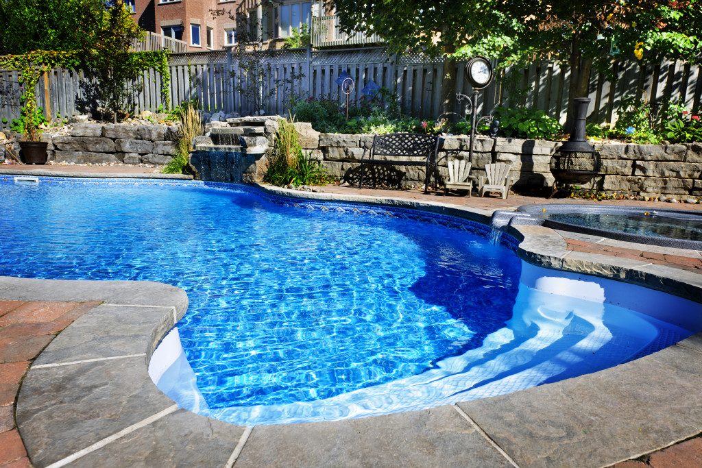 An irregularly shaped pool with an adjoining hot tub