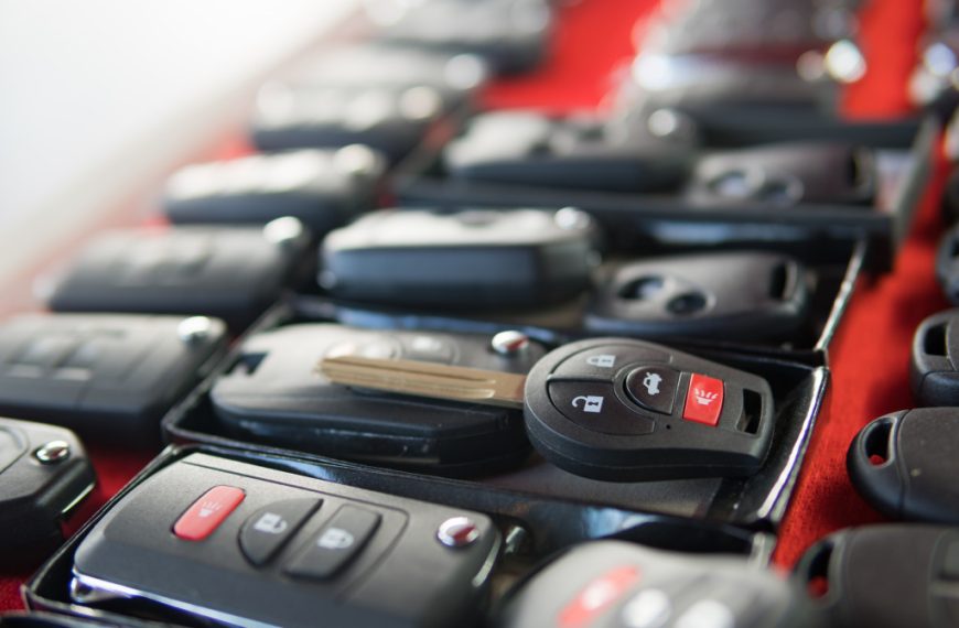 Several rows of car keys on a long red table.