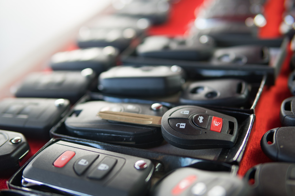 Several rows of car keys on a long red table.