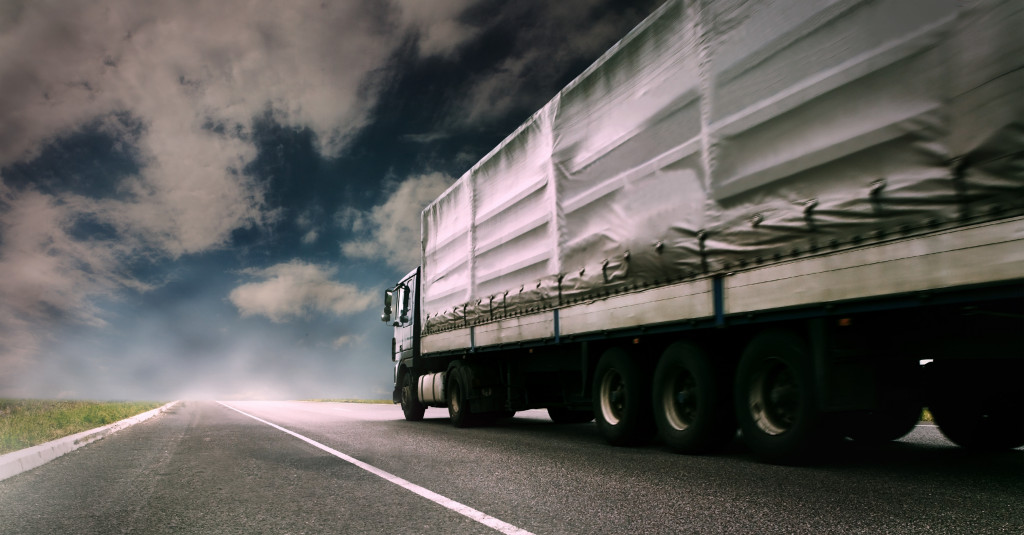 A truck delivering barrels of oil