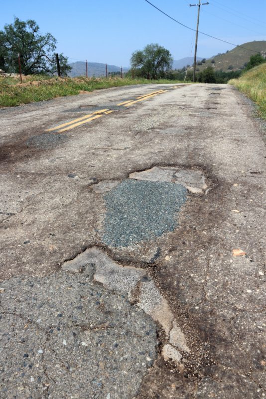 Pothole road; damaged roadway surface