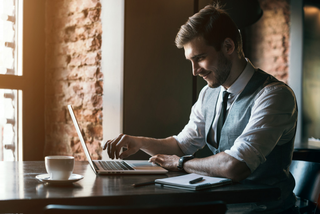 A handsome man working on his laptop in a cafe