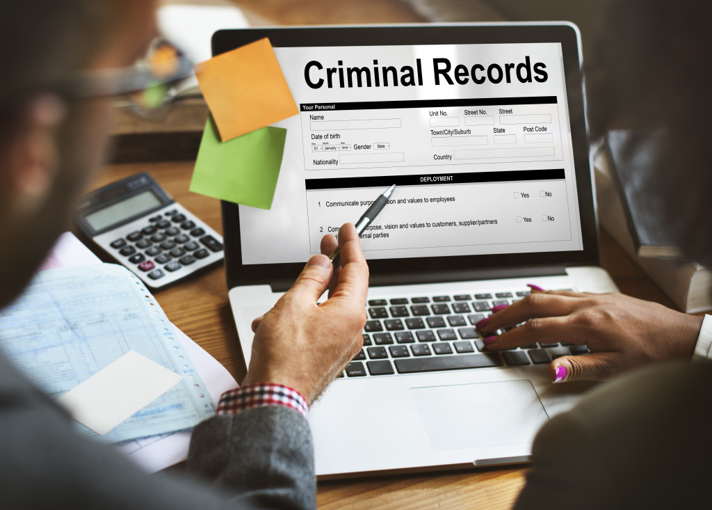 personnel checking a person's criminal record via a laptop