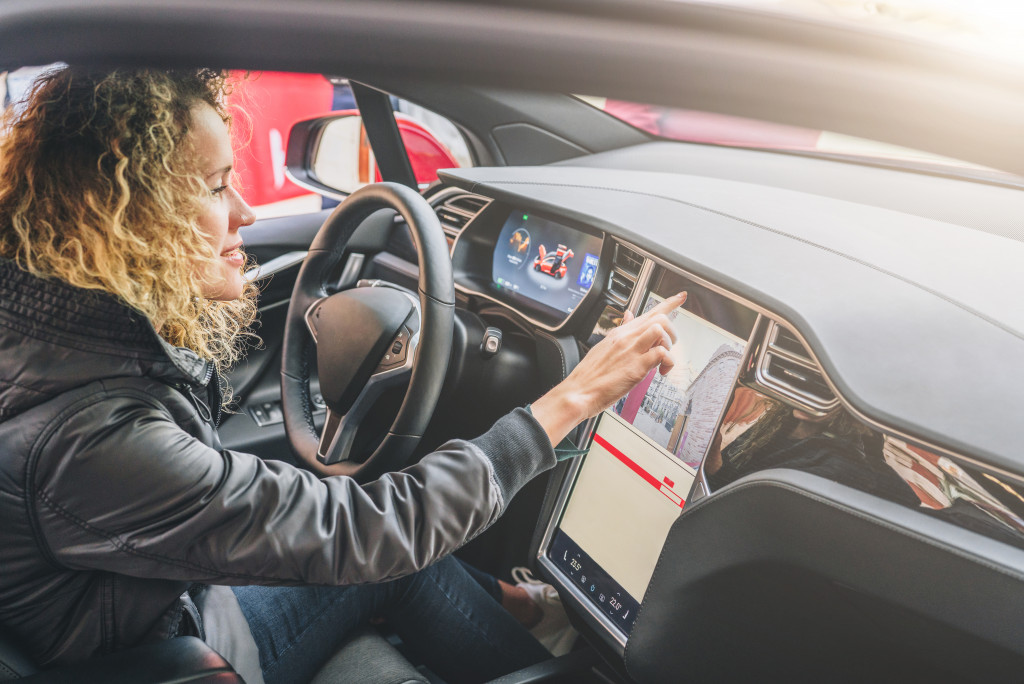 a female driver interacting with car's dashboard