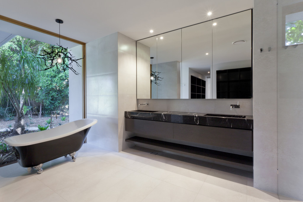 A bathroom with a bathtub and a large sink with mirror