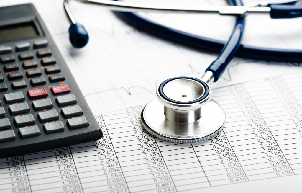 A stethoscope and a calculator on a financial documents