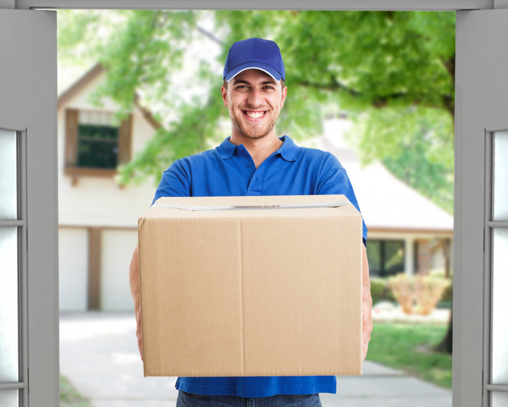 Young delivery man bringing a box for delivery.