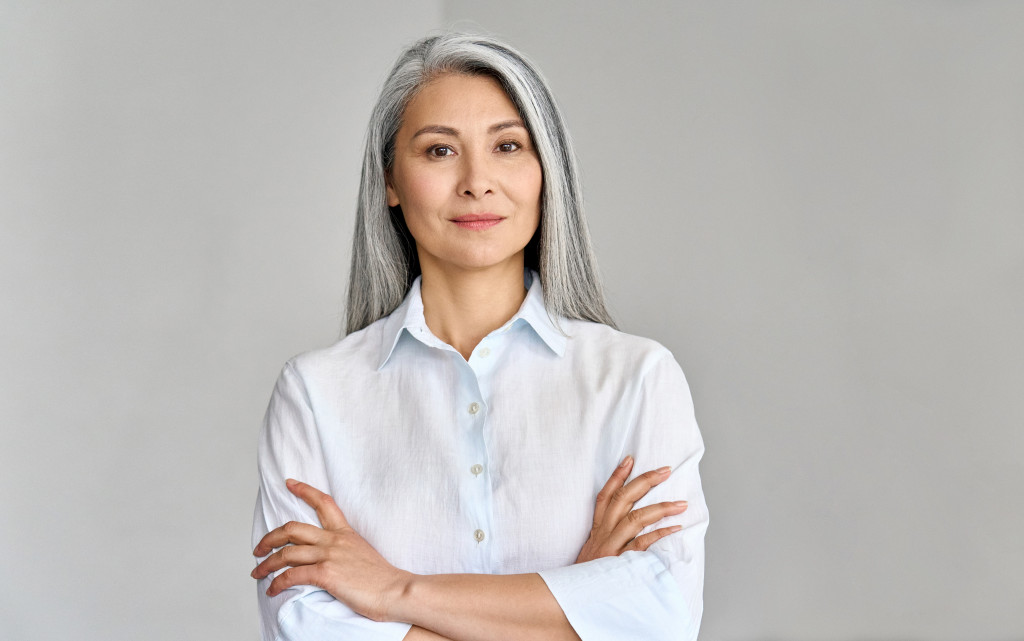 A mature woman looking professional in front of a gray background