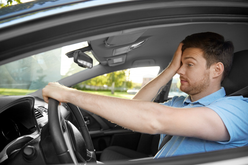 A driver rubbing his eyes, feeling tired