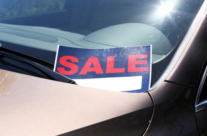 a sale sign on a secondhand car