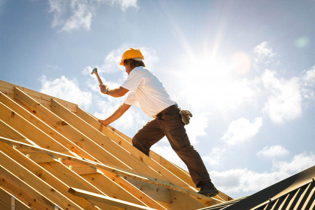 man working on a roof with safety helmet