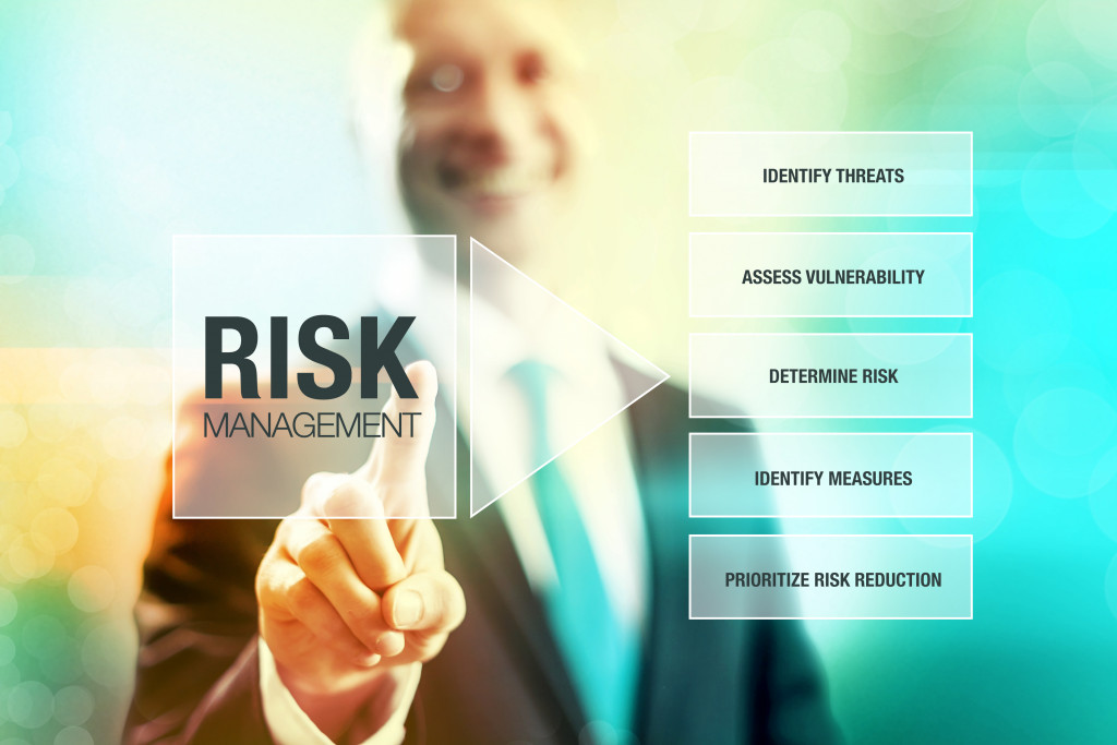 businessman smiling while touching risk management icon with concept map