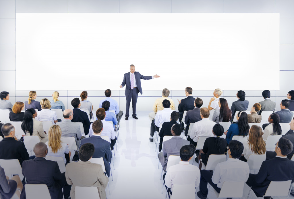 male speaker in front of a big business audience