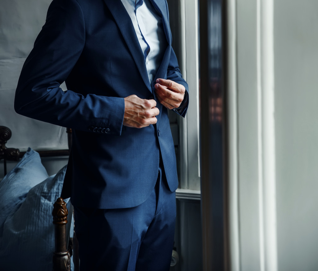 man in a suit dressing up in bedroom