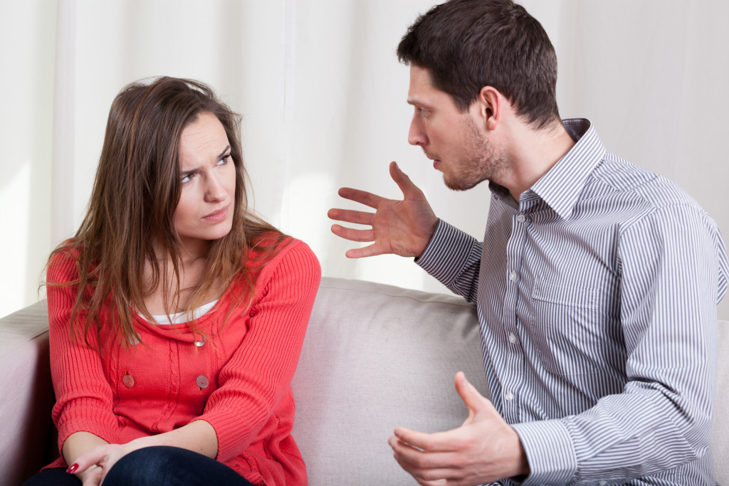 couple arguing sitting on the couch