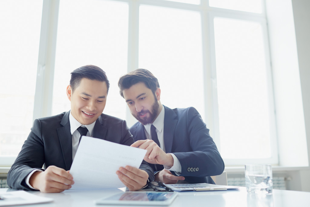 Two executives reviewing a contract in an office.