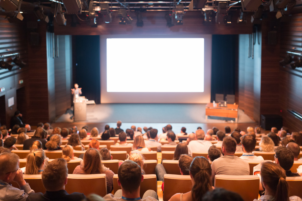 industry conference with speaker in the front and many audiences seated