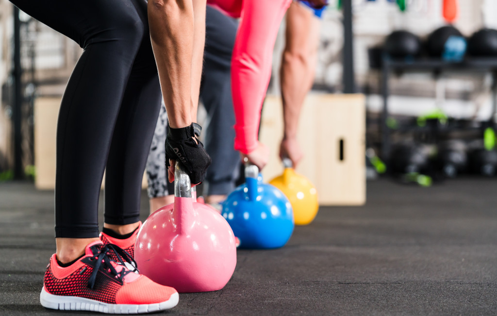 office gym with employees using kettlebells as weights