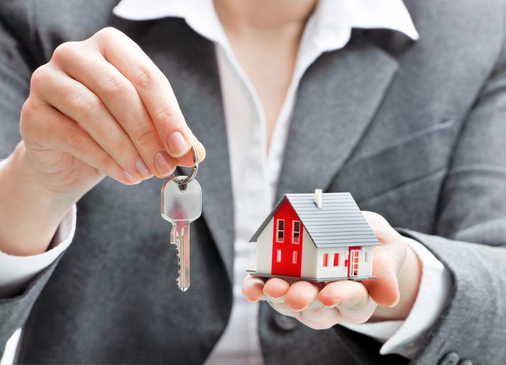 real estate agent with house model and keys