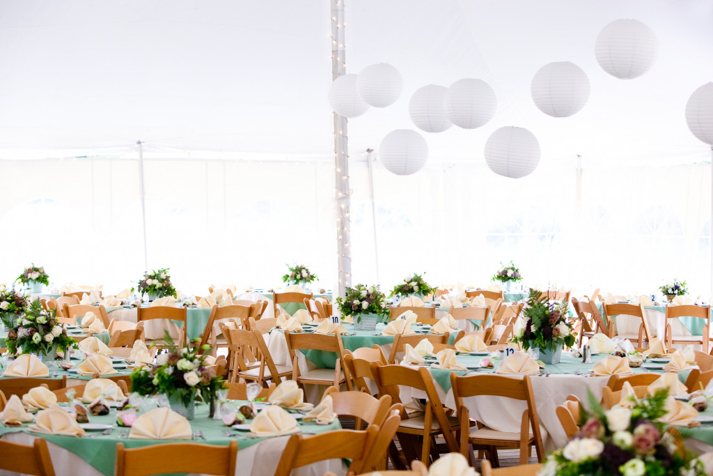 a tent with balloons, decorations, tables, and chairs for a catering service