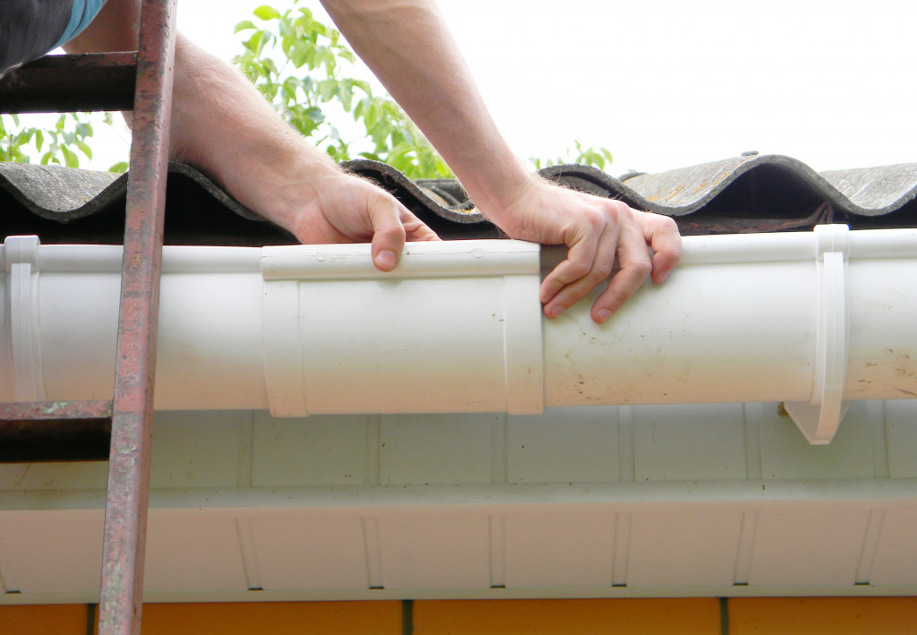 A man cleaning a roof gutter