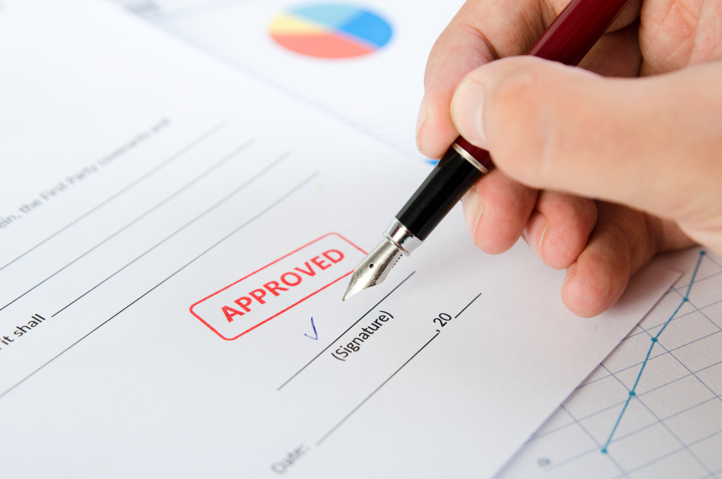 building permit document closeup with person signing