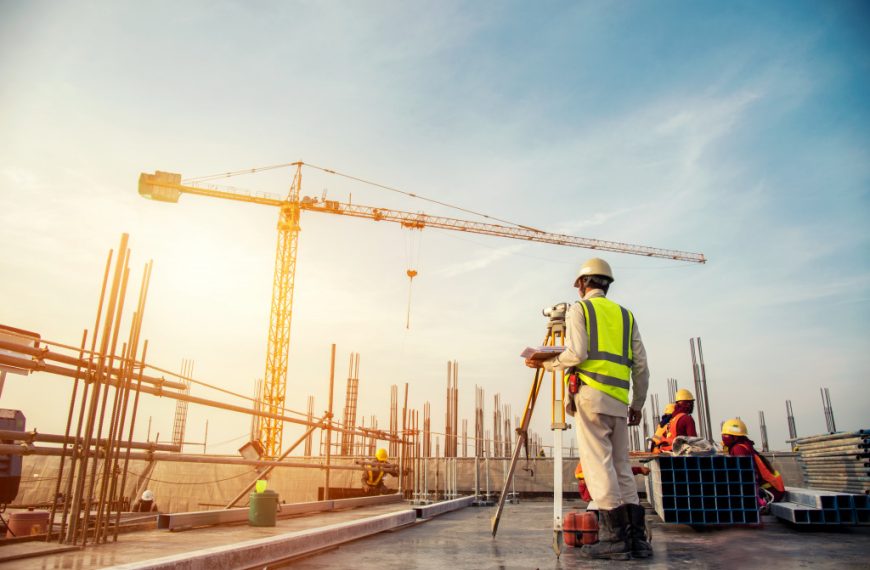 An image of a construction site with a crane and workers