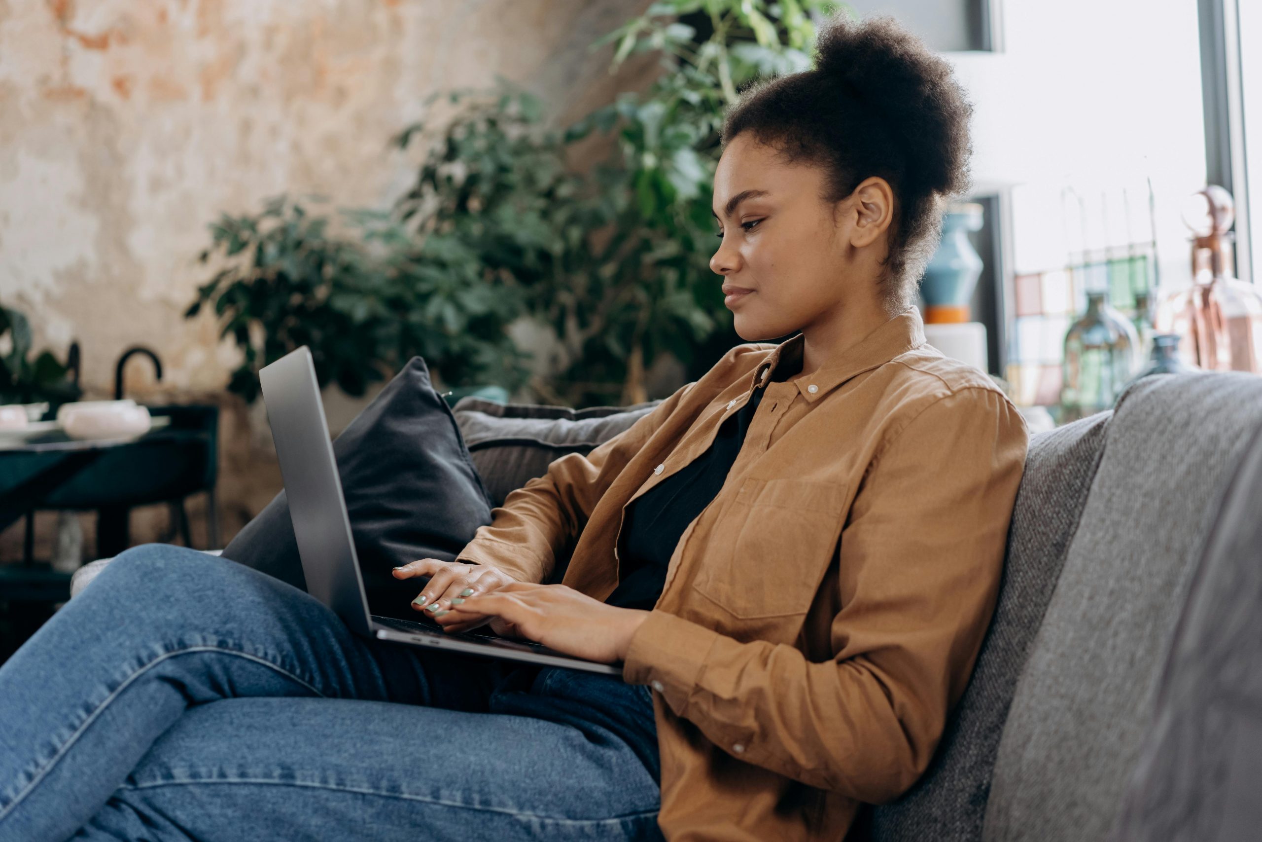 woman on a couch, using a laptop